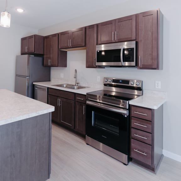 a kitchen with wooden cabinets and stainless steel appliances