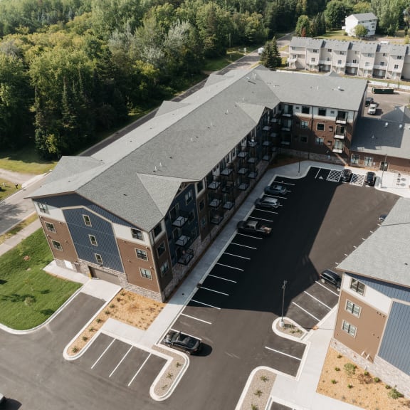 an aerial view of an apartment building with a parking lot