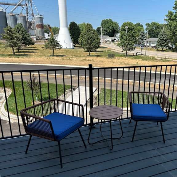 a patio with two chairs and a table on a balcony
