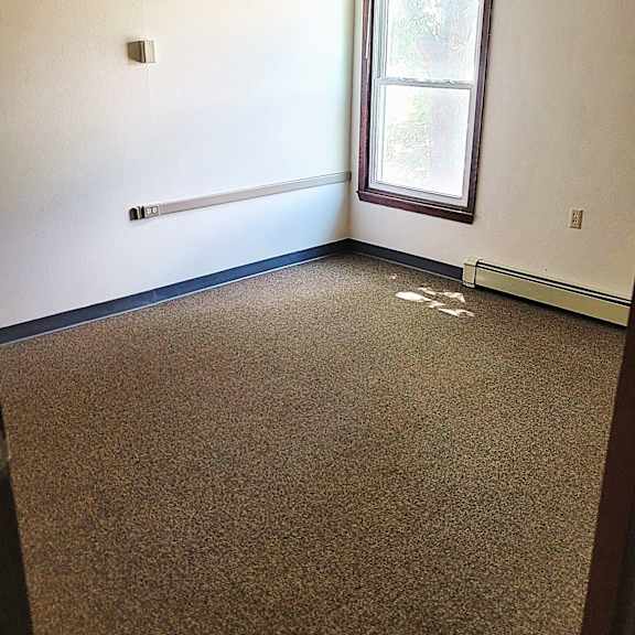a room with a carpeted floor and a window.