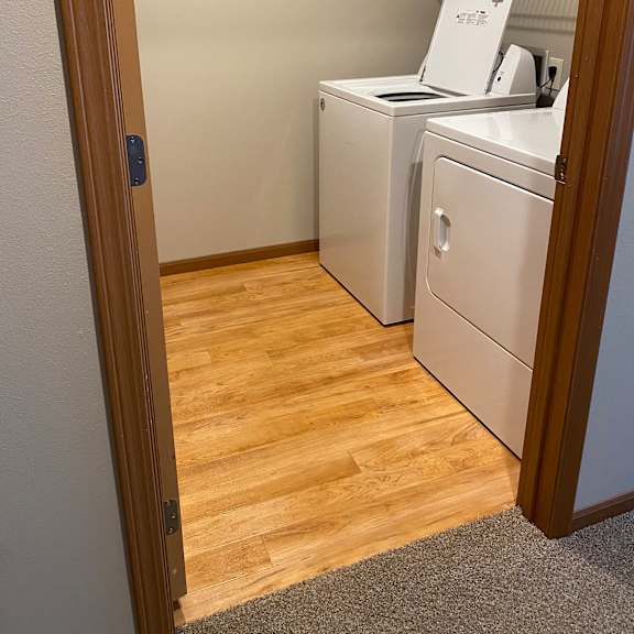 a white air conditioner unit is installed on the ceiling of a room with wooden paneling.
