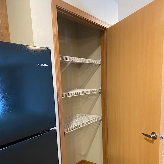 a wooden cabinet with a black door and a silver handle.