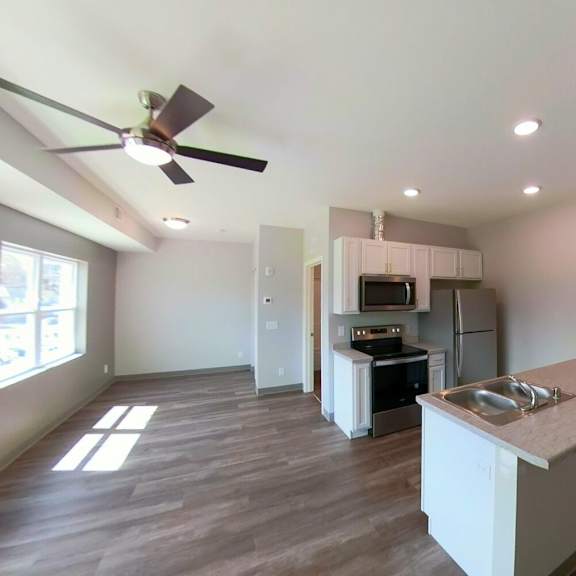 a kitchen with a sink and a ceiling fan