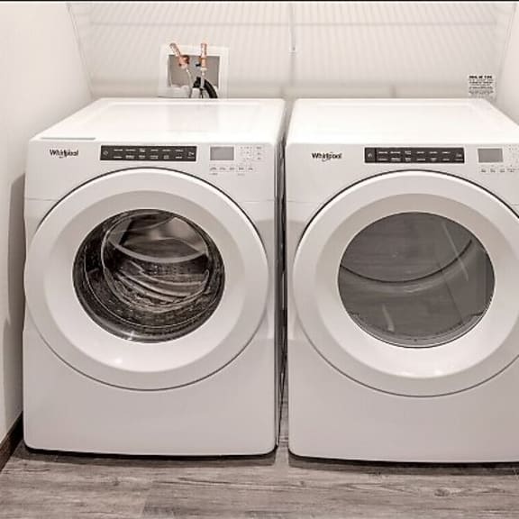 two washing machines sitting next to each other in a laundry room