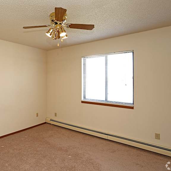 a room with a ceiling fan and a window.