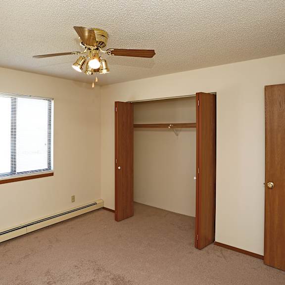 a room with a ceiling fan and a window.
