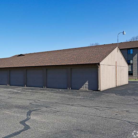 a large, empty parking lot with a long building in the background.