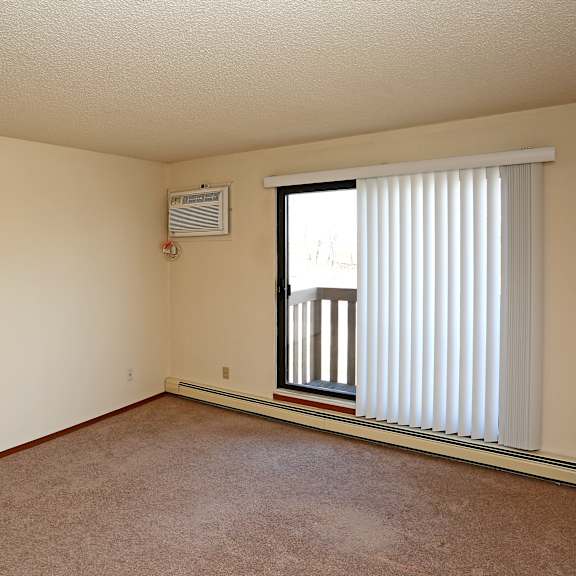 a room with a window covered by white blinds.