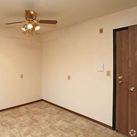 a room with a ceiling fan and a door.