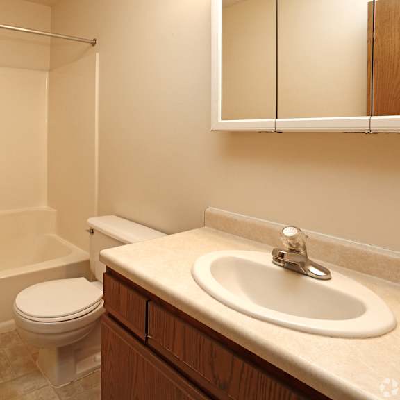 a white bathroom with a toilet, sink, and bathtub.