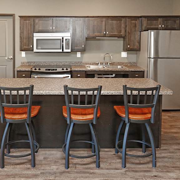 a kitchen with a large island with four chairs