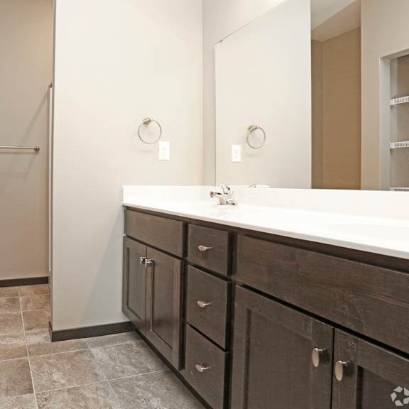 a bathroom with a large mirror and a sink and a toilet