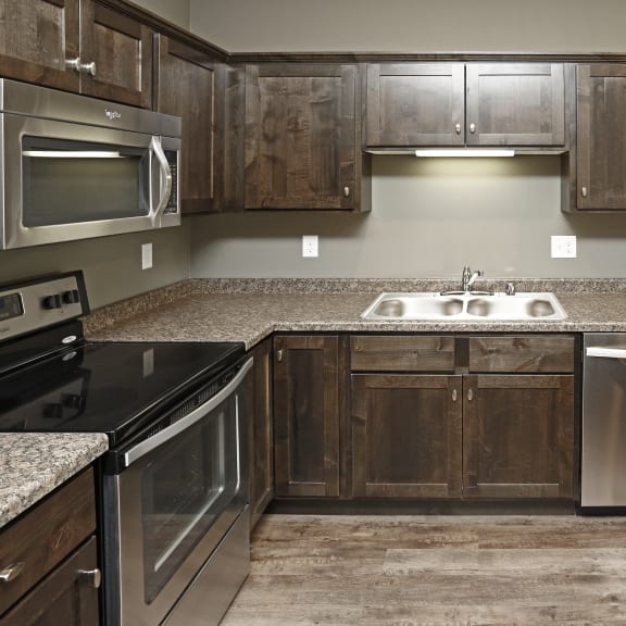 a kitchen with wooden cabinets and stainless steel appliances