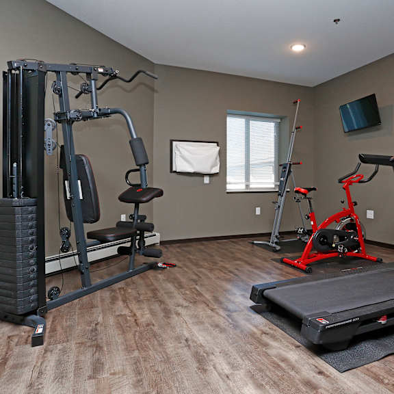 a gym with exercise equipment and a tv