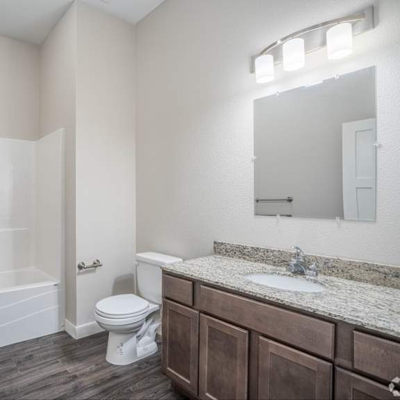 a bathroom with a toilet, sink, and bathtub.