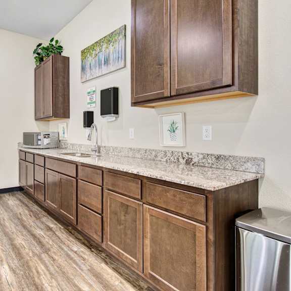 a kitchen with wooden cabinets and a marble countertop.
