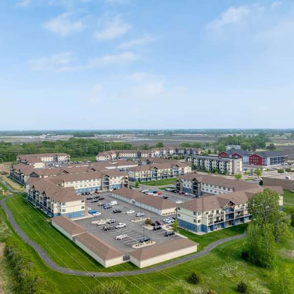 a large building complex with a parking lot in front of it.