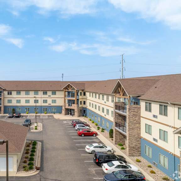 a parking lot in front of a building with cars parked.