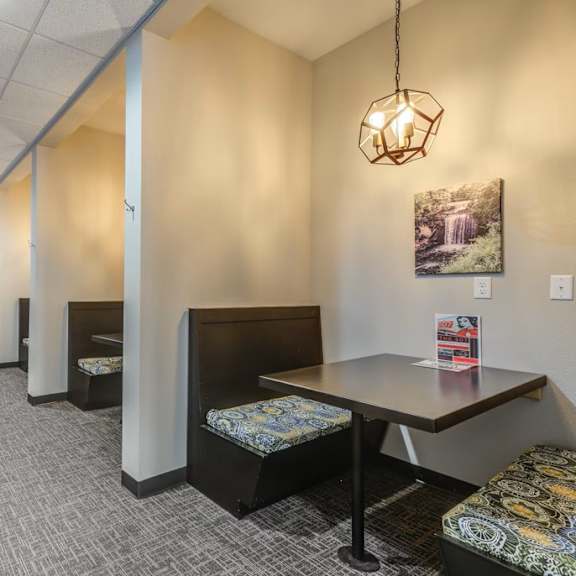 a long hallway with a table and chairs at the end.