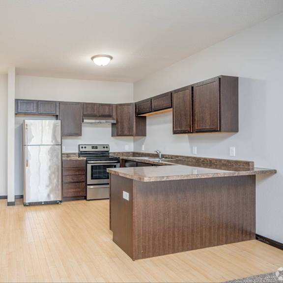 a kitchen with a wooden island and stainless steel appliances.
