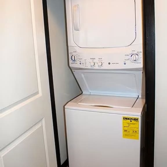 a white dishwasher is in a dark room.