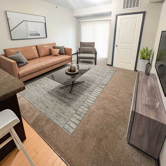 a living room with a brown couch and a grey rug.