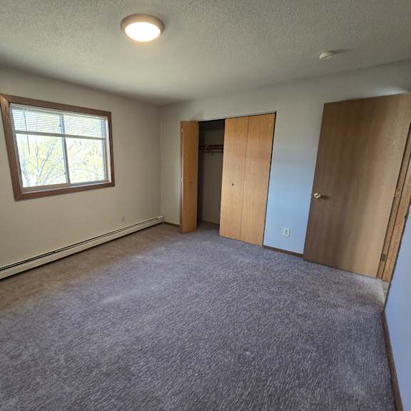 a room with a window and a carpeted floor.