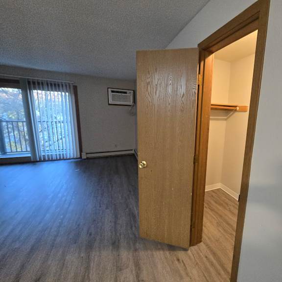 a room with a wooden door and a window with blinds.