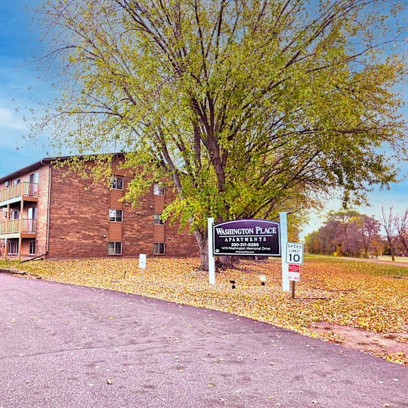 a sign for washington place apartments stands in front of a brick building.
