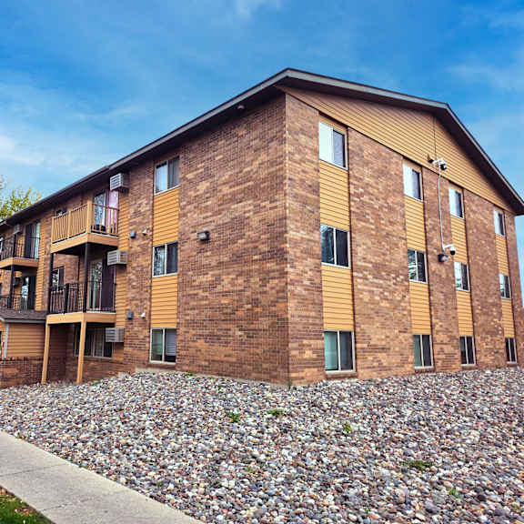 a large brick building with a grassy area in front.