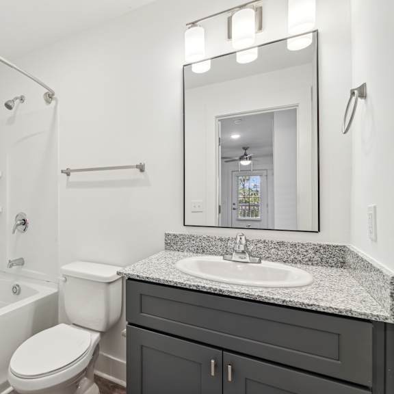 Thumbnail 7 of 7 A white bathroom with a toilet, sink, and bathtub at The Parker North Augusta, North Augusta, SC, 29841