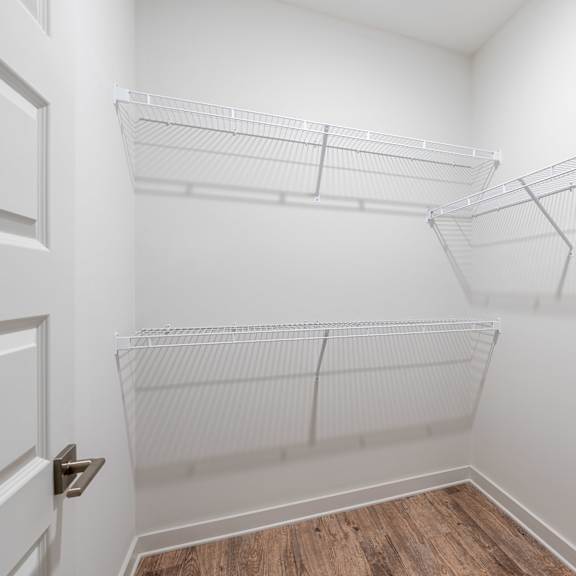 a white closet with shelves and a door.