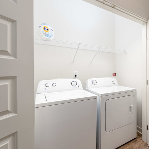 a white washing machine and dryer in a small laundry room.
