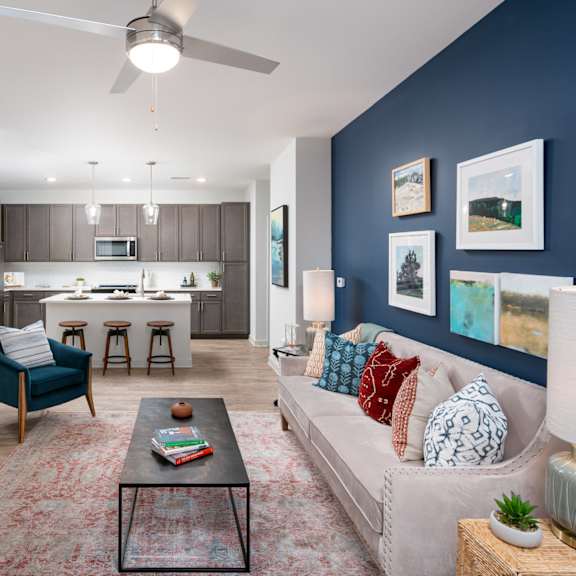 a living room with a blue chair and a black coffee table.