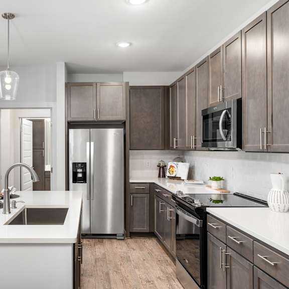a modern kitchen with a stainless steel refrigerator and wooden cabinets.