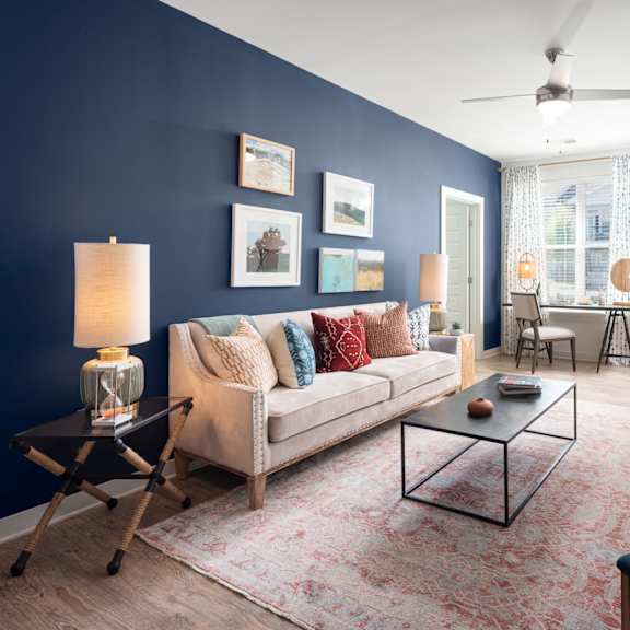 a living room with a couch, a coffee table, and a lamp.