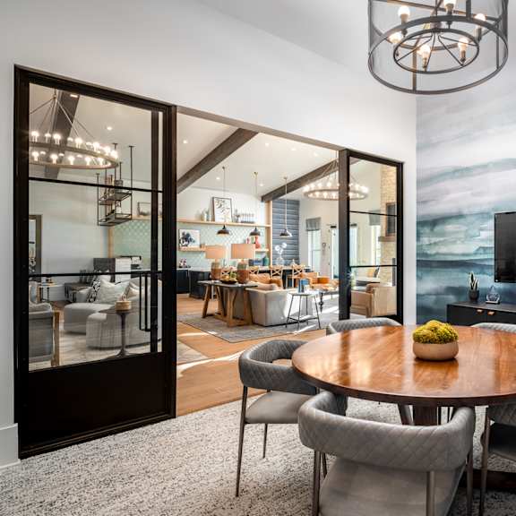 a modern dining room with a wooden table and grey chairs.