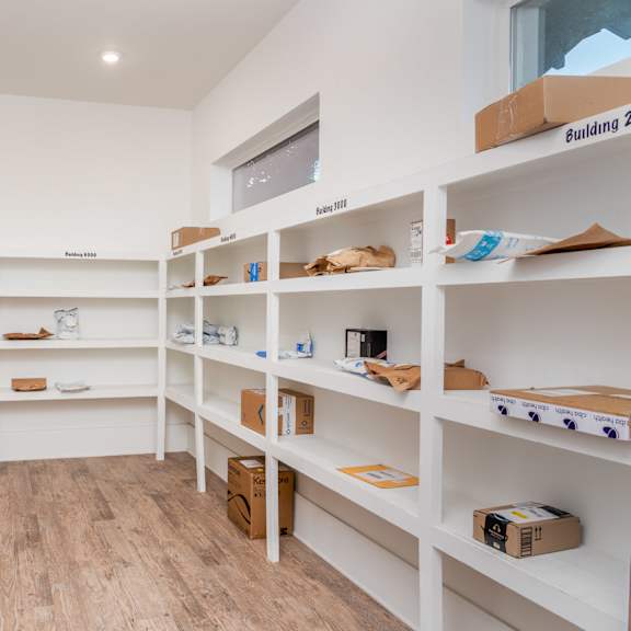 a room with white shelves and boxes on them.