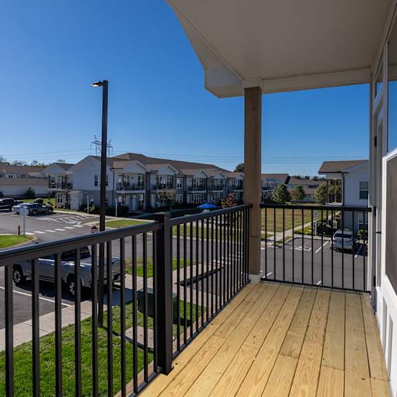 a balcony with a black railing and a white wall.