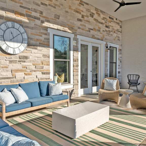 a living room with a blue couch and a stone wall.