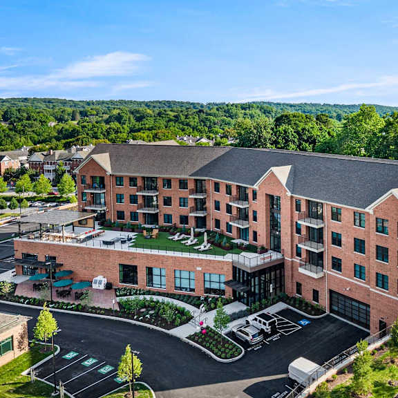 a large red brick building with a parking lot in front.