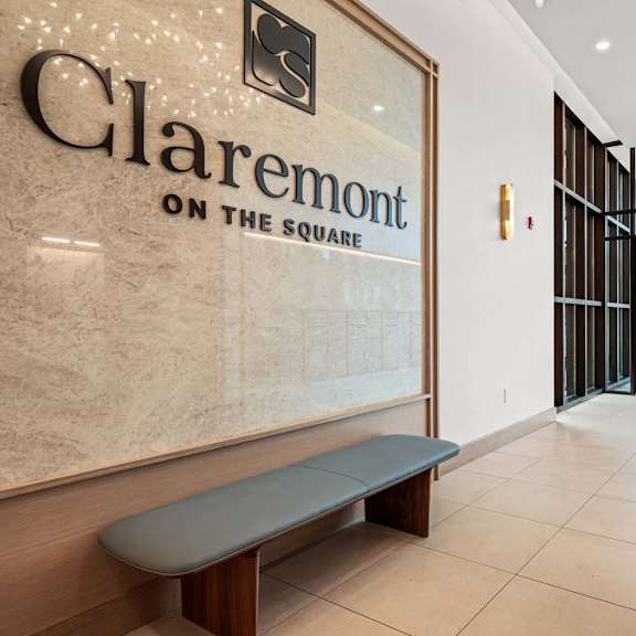 a hallway with a bench and a sign that says claremont on the square.
