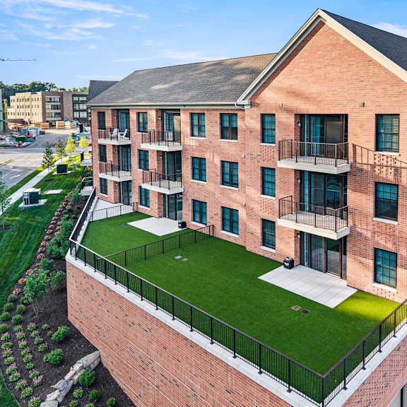 a red brick apartment building with a green lawn in the front.
