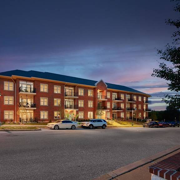 a large red brick building with a parking lot in front of it.