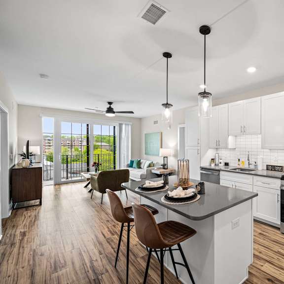 a modern kitchen with white cabinets and a wooden floor.