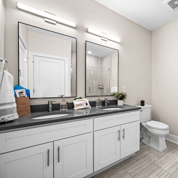 a bathroom with a toilet, sink, and mirror.