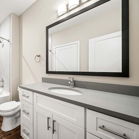 a white toilet sits in a bathroom next to a white bathtub.