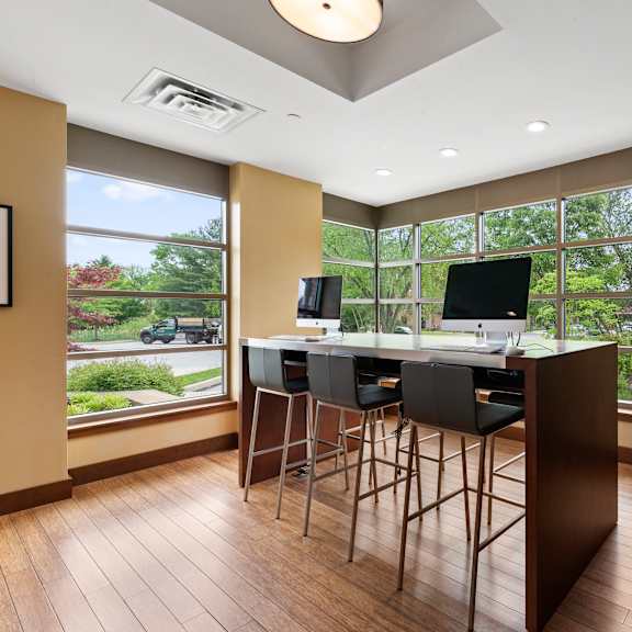 a modern kitchen with a bar stool and a television.