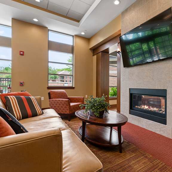 a living room with a fireplace and a flat screen tv mounted on the wall.
