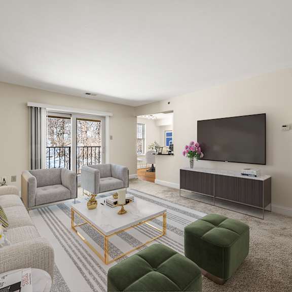 a living room with a grey sofa, a green ottoman, a coffee table, a television, and a window with a view of trees.